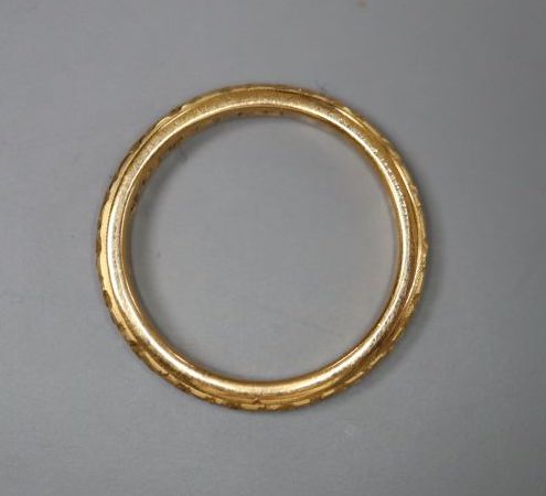 A late Victorian carved 22ct gold wedding band, size N/O,